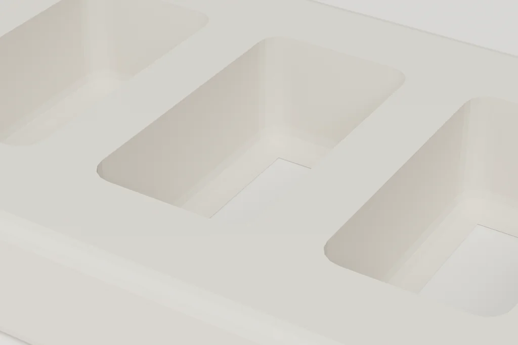 Close view of a moulded pulp insert tray showing three cavities and the walls between them.
