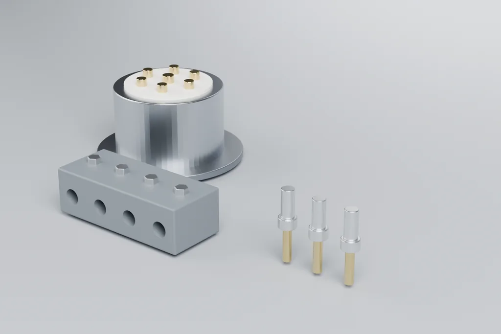 A metal circular connector with gold contacts on a white insulator face, a grey four-way terminal block, and three crimp contacts.