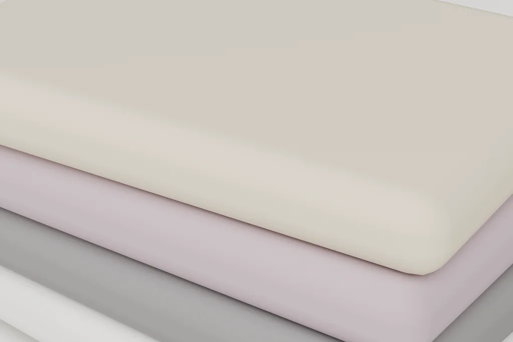 Close view of a stack of folded knits showing the fold edges and the tonal contrast between layers.
