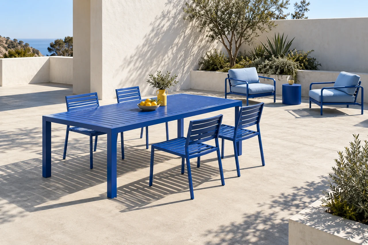 Original AI concept: cobalt blue table, side chairs and pale-blue lounge seating in a bright concrete courtyard.